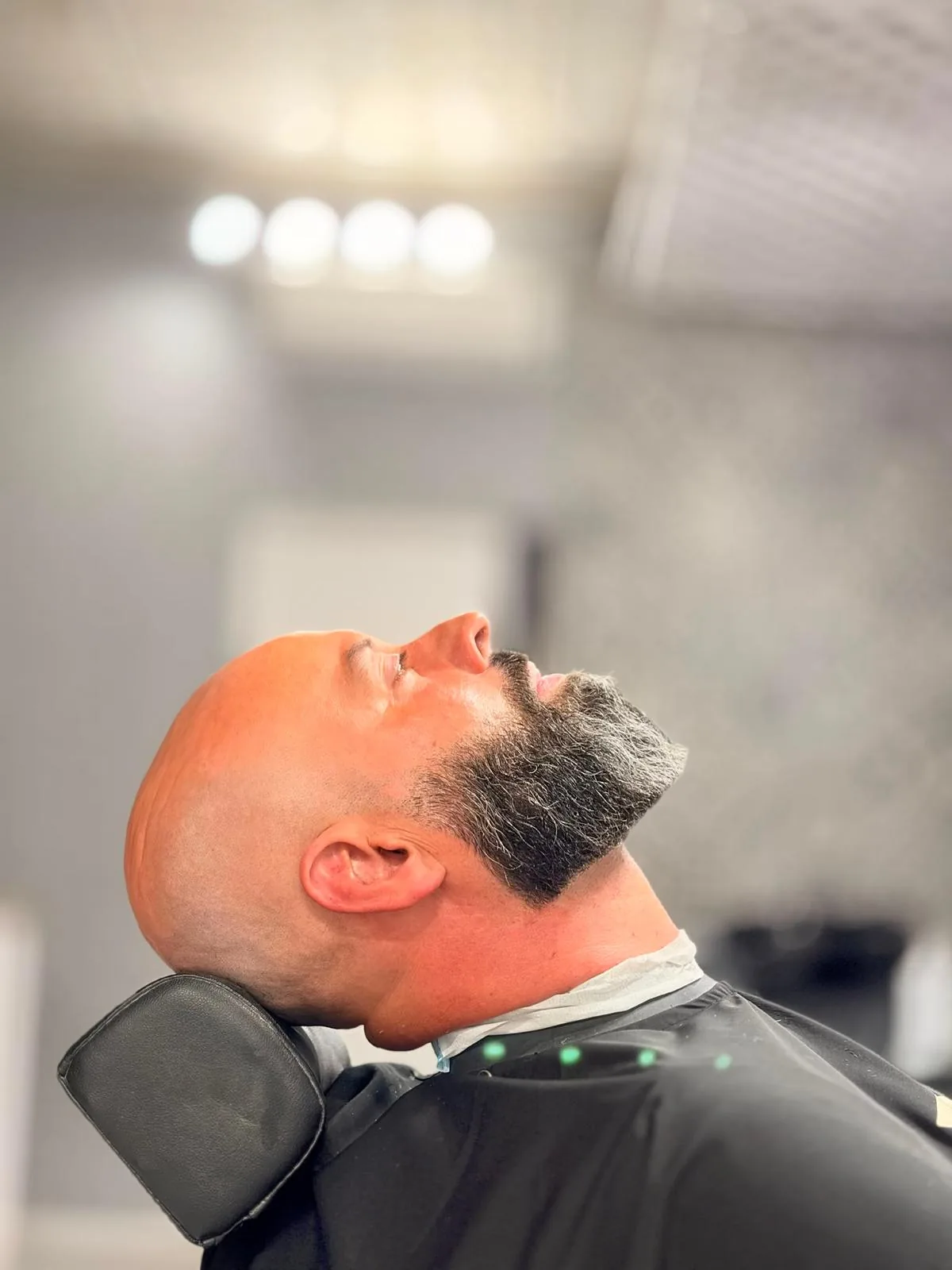Cabeza afeitada y barba perfilada